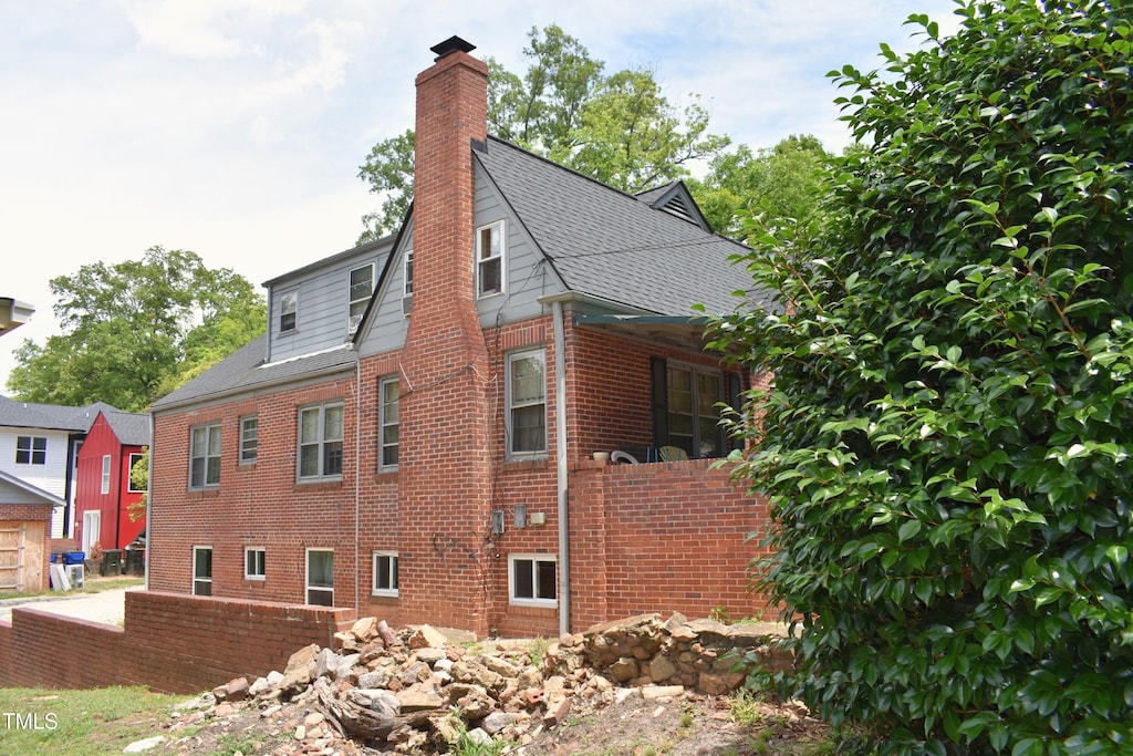 2210 Hope St, Raleigh, NC 27607 - view of side of property with a chimney, brick siding, and roof with shingles