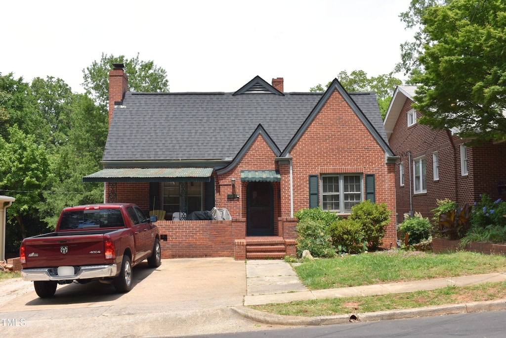 2210 Hope St, Raleigh, NC 27607 - english style home with brick siding, a chimney, and roof with shingles
