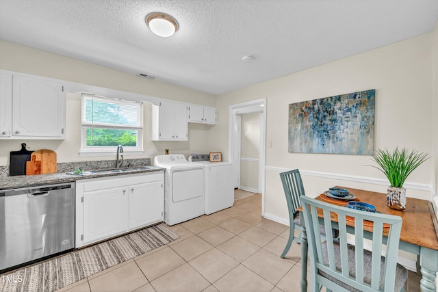 1220 Manassas Ct Unit B, Raleigh, NC 27609 - kitchen with stainless steel dishwasher, washing machine and clothes dryer, a sink, white cabinets, and a textured ceiling