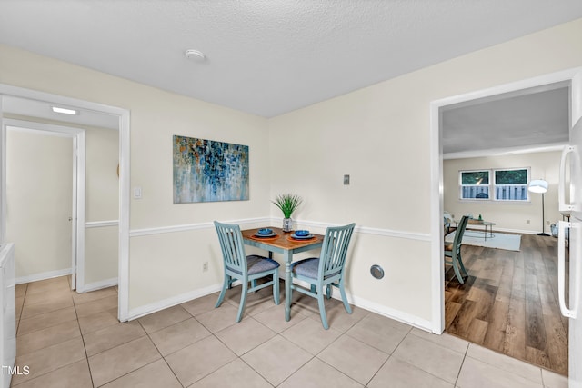 1220 Manassas Ct Unit B, Raleigh, NC 27609 - dining space featuring light tile patterned flooring, baseboards, and a textured ceiling