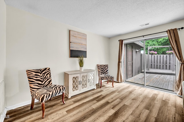 1220 Manassas Ct Unit B, Raleigh, NC 27609 - living area featuring wood finished floors, a textured ceiling, and baseboards