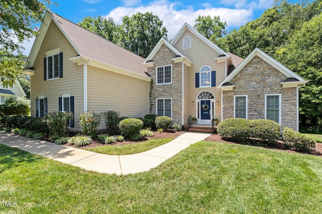 2628 Hunters Meadow Ln, Raleigh, NC 27606 - traditional home featuring stone siding, a front yard, and roof with shingles