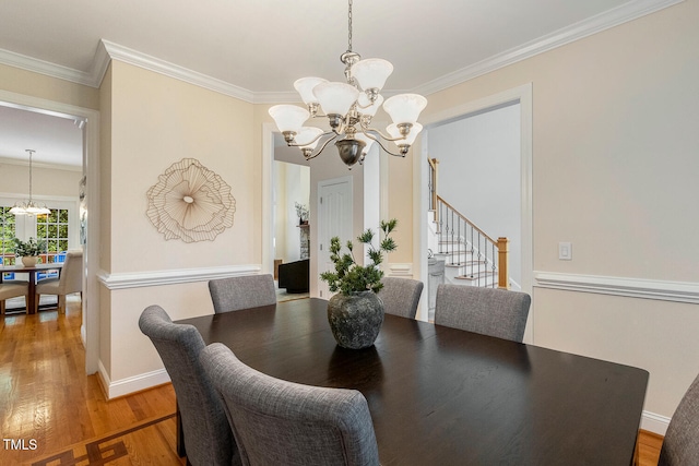 2628 Hunters Meadow Ln, Raleigh, NC 27606 - dining room featuring a chandelier, wood finished floors, ornamental molding, and stairs