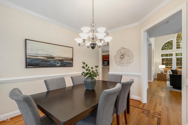 2628 Hunters Meadow Ln, Raleigh, NC 27606 - dining area with a chandelier, light wood finished floors, and ornamental molding