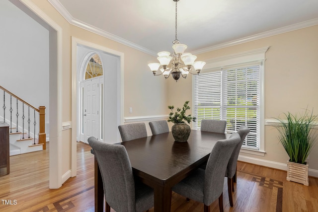 2628 Hunters Meadow Ln, Raleigh, NC 27606 - dining room with a chandelier, ornamental molding, stairs, and light wood finished floors