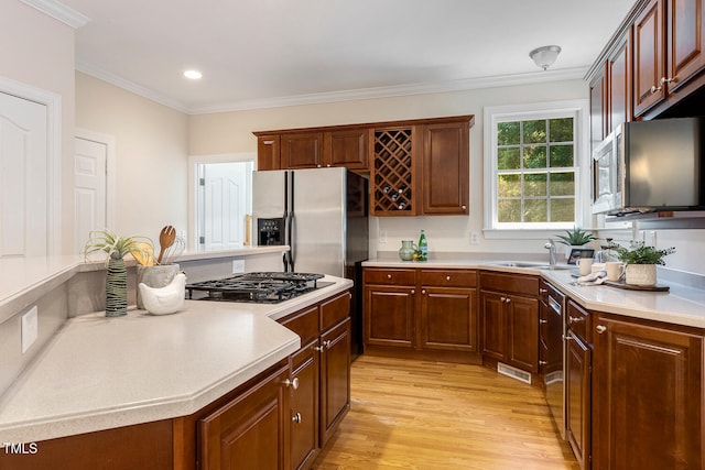 2628 Hunters Meadow Ln, Raleigh, NC 27606 - kitchen featuring stainless steel appliances, light wood finished floors, light countertops, crown molding, and recessed lighting