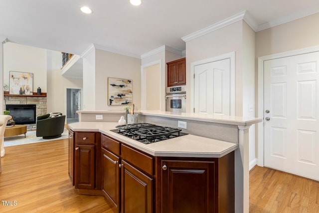 2628 Hunters Meadow Ln, Raleigh, NC 27606 - kitchen with black gas cooktop, light countertops, light wood-style flooring, oven, and ornamental molding