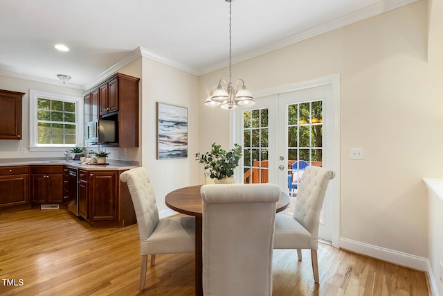 2628 Hunters Meadow Ln, Raleigh, NC 27606 - dining space featuring light wood finished floors, crown molding, a chandelier, and french doors