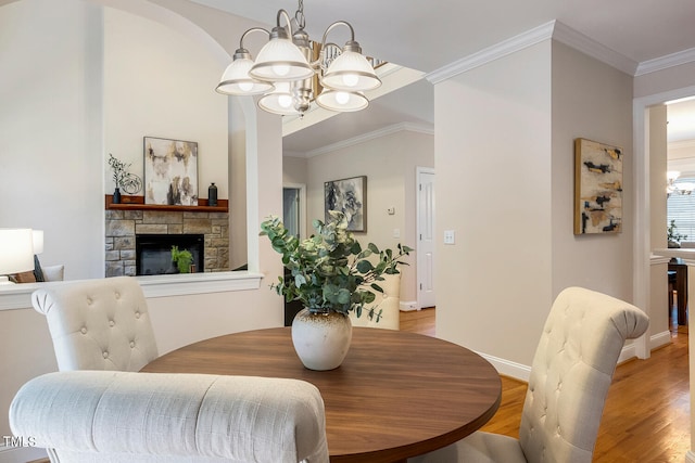 2628 Hunters Meadow Ln, Raleigh, NC 27606 - dining space with a chandelier, light wood-type flooring, a fireplace, and crown molding