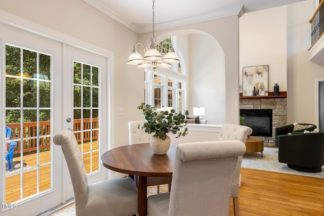 2628 Hunters Meadow Ln, Raleigh, NC 27606 - dining space with a chandelier, a stone fireplace, light wood-type flooring, and ornamental molding