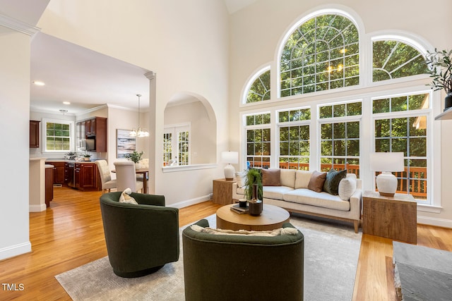 2628 Hunters Meadow Ln, Raleigh, NC 27606 - living area featuring light wood-style floors, a chandelier, a high ceiling, and crown molding