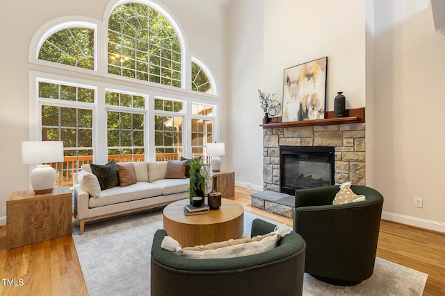 2628 Hunters Meadow Ln, Raleigh, NC 27606 - living room featuring wood finished floors, a fireplace, and a towering ceiling