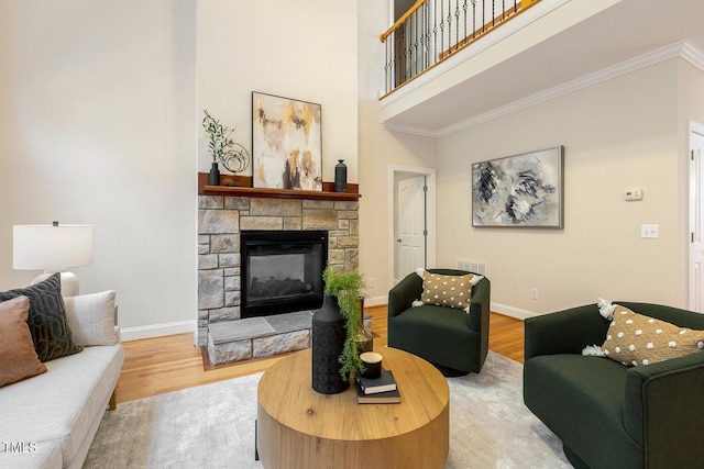 2628 Hunters Meadow Ln, Raleigh, NC 27606 - living area with wood finished floors, crown molding, a stone fireplace, and a high ceiling