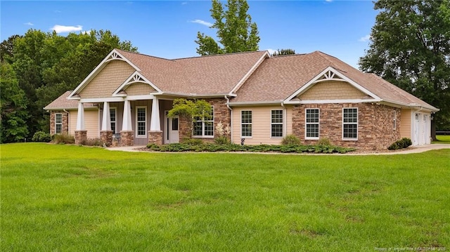 330 Wellington Rd, Saint Pauls, NC 28384 - craftsman-style house with stone siding, a front lawn, a porch, and a shingled roof