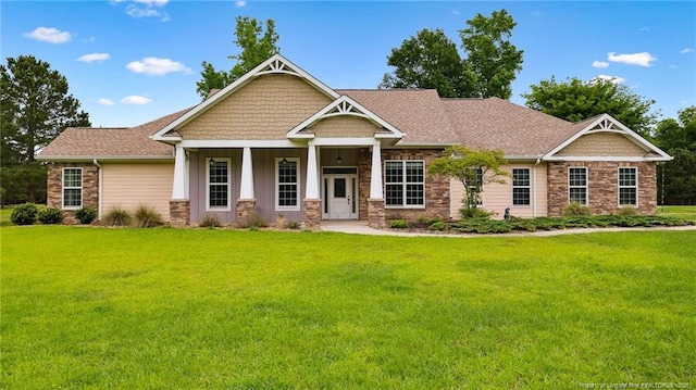 330 Wellington Rd, Saint Pauls, NC 28384 - craftsman inspired home with stone siding, board and batten siding, a front lawn, and covered porch