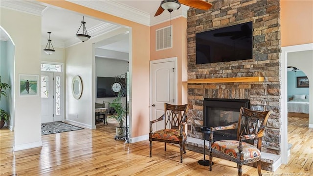 330 Wellington Rd, Saint Pauls, NC 28384 - entryway with wood finished floors, a ceiling fan, arched walkways, a fireplace, and crown molding