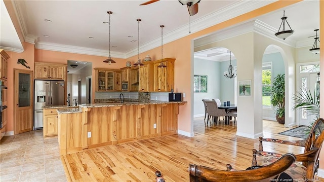 330 Wellington Rd, Saint Pauls, NC 28384 - kitchen featuring stainless steel appliances, a peninsula, light stone countertops, glass insert cabinets, and arched walkways