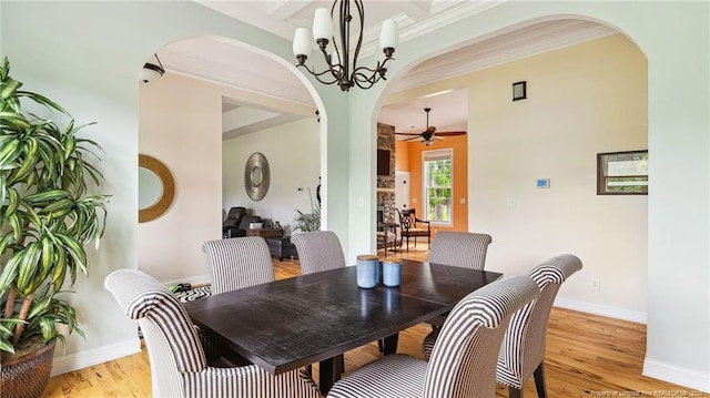 330 Wellington Rd, Saint Pauls, NC 28384 - dining area featuring ceiling fan, arched walkways, light wood-type flooring, ornamental molding, and a chandelier