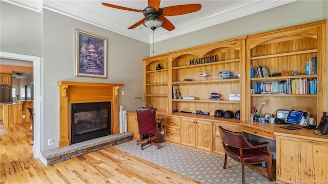330 Wellington Rd, Saint Pauls, NC 28384 - office with built in desk, a glass covered fireplace, a ceiling fan, ornamental molding, and light wood-style flooring