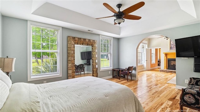 330 Wellington Rd, Saint Pauls, NC 28384 - bedroom featuring a tray ceiling, arched walkways, wood finished floors, and multiple windows