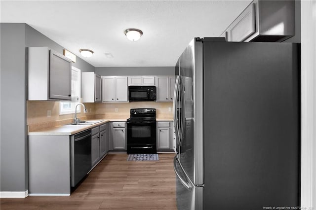 195 Cape Fear Rd, Raeford, NC 28376 - kitchen featuring black appliances, a sink, wood finished floors, light countertops, and gray cabinets
