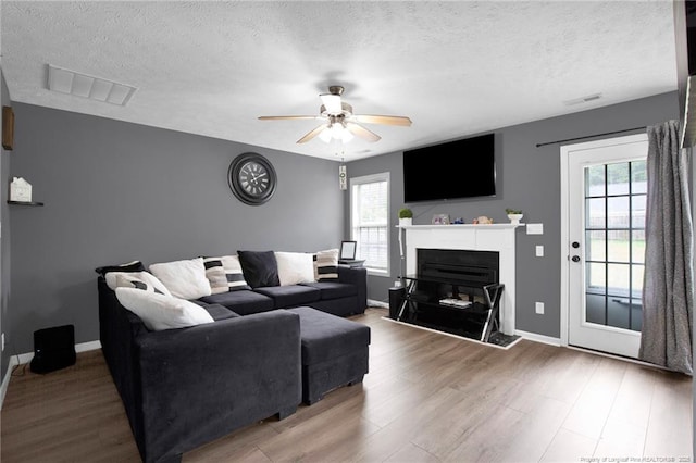 195 Cape Fear Rd, Raeford, NC 28376 - living area with healthy amount of natural light, a ceiling fan, wood finished floors, a textured ceiling, and baseboards