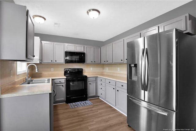 195 Cape Fear Rd, Raeford, NC 28376 - kitchen featuring black appliances, a sink, light countertops, wood finished floors, and gray cabinetry
