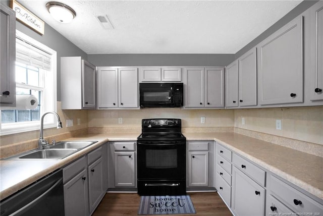 195 Cape Fear Rd, Raeford, NC 28376 - kitchen with black appliances, a sink, dark wood-style floors, a textured ceiling, and light countertops