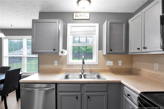 195 Cape Fear Rd, Raeford, NC 28376 - kitchen featuring dishwasher, a sink, gray cabinets, a textured ceiling, and healthy amount of natural light