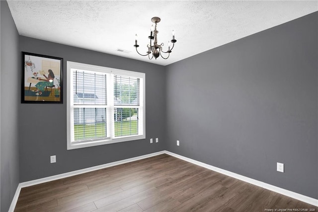 195 Cape Fear Rd, Raeford, NC 28376 - unfurnished room with a chandelier, dark wood finished floors, a textured ceiling, and baseboards