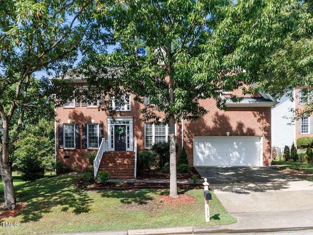 313 Hardwick Dr, Durham, NC 27713 - colonial house featuring driveway, brick siding, a front lawn, and an attached garage