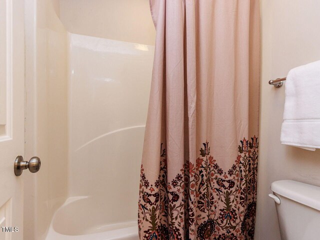 313 Hardwick Dr, Durham, NC 27713 - bathroom featuring toilet and shower / bathtub combination with curtain