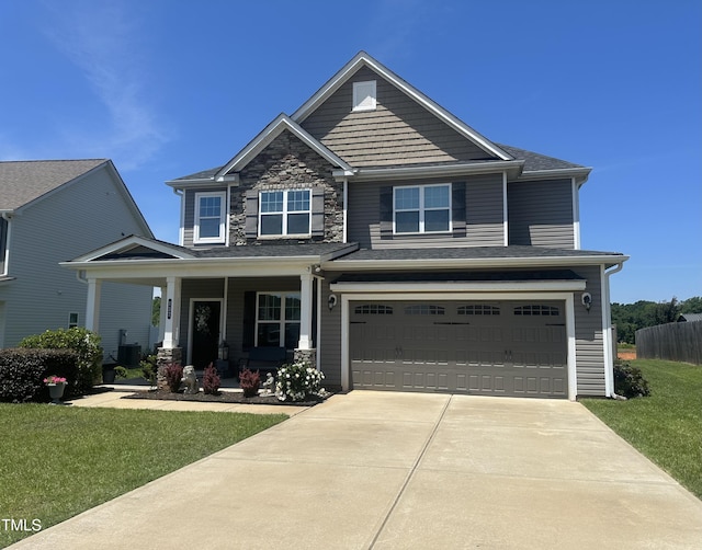 137 Campaign Dr, Mebane, NC 27302 - craftsman house with covered porch, concrete driveway, an attached garage, a front lawn, and stone siding