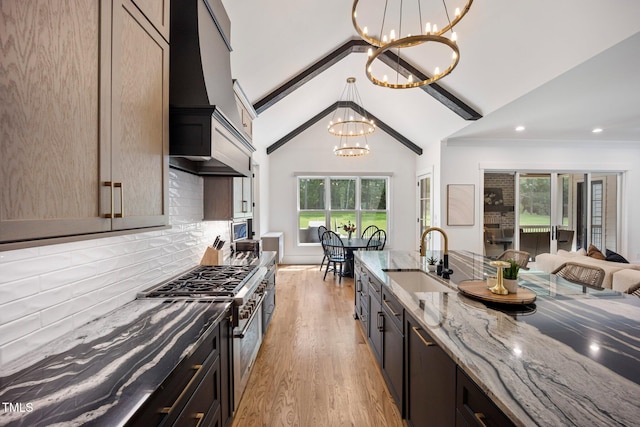 2713 Trifle Ln, Wake Forest, NC 27587 - kitchen featuring a sink, a chandelier, custom exhaust hood, stainless steel stove, and light stone countertops