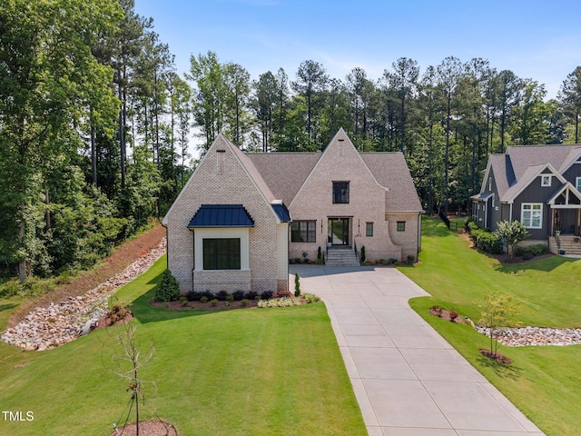 2713 Trifle Ln, Wake Forest, NC 27587 - view of front of property featuring driveway, a front yard, a standing seam roof, and brick siding
