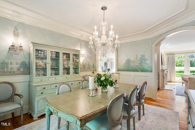 801 Pinehurst Dr, Chapel Hill, NC 27517 - dining space featuring arched walkways, a chandelier, light wood-style floors, a decorative wall, and wainscoting