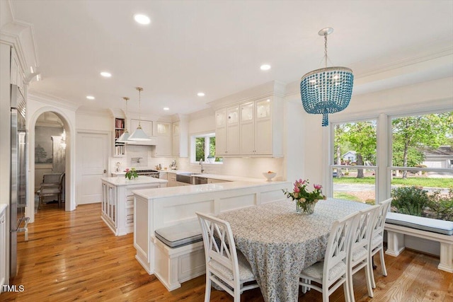 801 Pinehurst Dr, Chapel Hill, NC 27517 - dining space featuring arched walkways, a chandelier, crown molding, recessed lighting, and light wood-style flooring