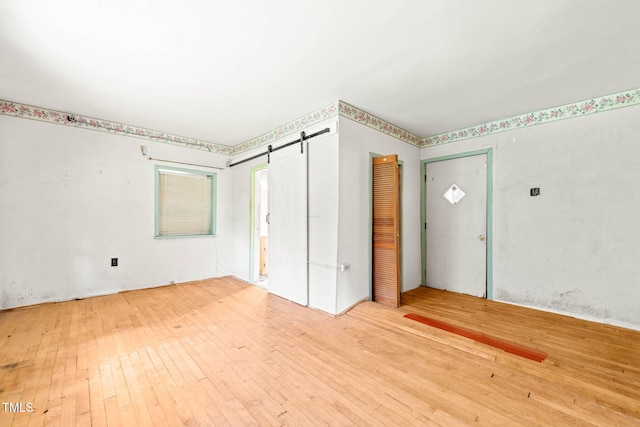 211 Cool Spring Rd, Durham, NC 27713 - unfurnished bedroom featuring hardwood / wood-style floors and a barn door