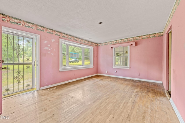 211 Cool Spring Rd, Durham, NC 27713 - unfurnished room with plenty of natural light, a textured ceiling, hardwood / wood-style flooring, and baseboards
