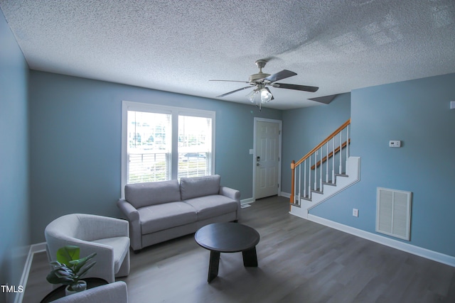 1806 Stroll Cir, Fuquay Varina, NC 27526 - living room with wood finished floors, stairway, ceiling fan, baseboards, and a textured ceiling