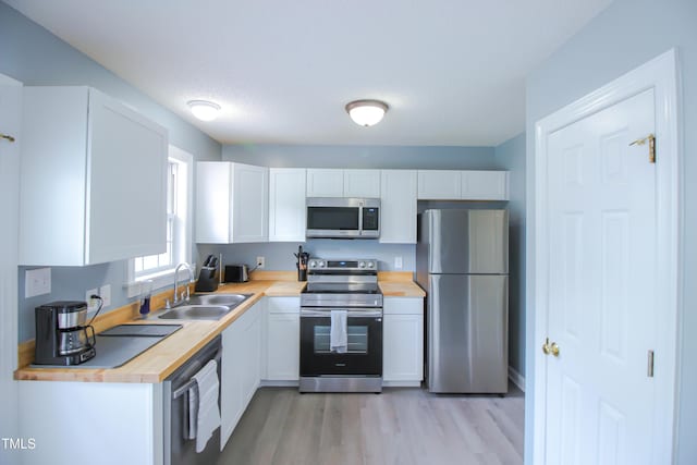 1806 Stroll Cir, Fuquay Varina, NC 27526 - kitchen with appliances with stainless steel finishes, butcher block countertops, a sink, and white cabinets