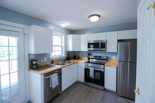 1806 Stroll Cir, Fuquay Varina, NC 27526 - kitchen with appliances with stainless steel finishes, a sink, butcher block counters, white cabinetry, and light wood finished floors