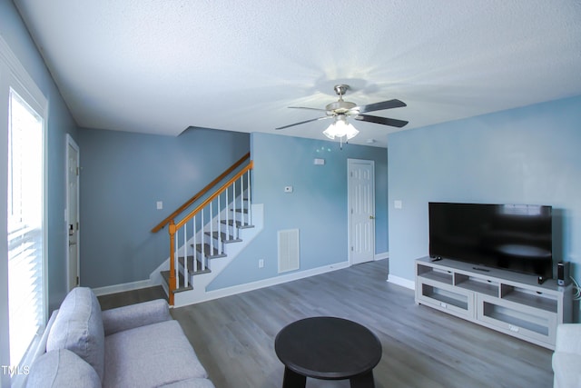 1806 Stroll Cir, Fuquay Varina, NC 27526 - living room featuring stairway, a textured ceiling, ceiling fan, wood finished floors, and baseboards