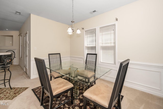 4009 Patriot Ridge Ct, Raleigh, NC 27610 - dining room with a chandelier, light colored carpet, wainscoting, and a decorative wall