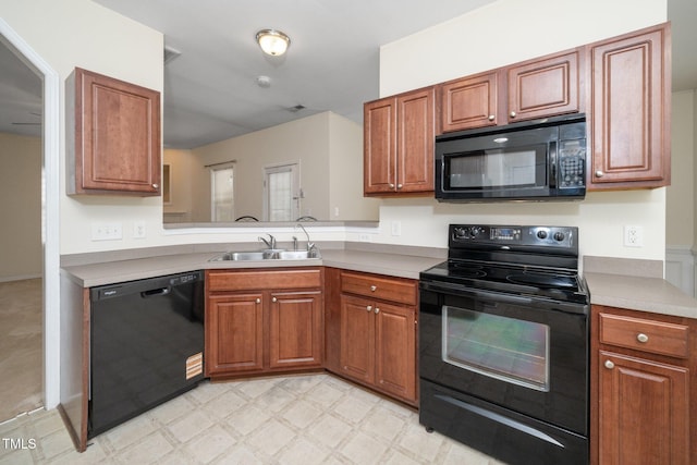 4009 Patriot Ridge Ct, Raleigh, NC 27610 - kitchen with black appliances, a sink, brown cabinetry, and light floors