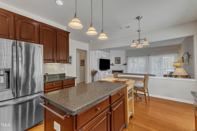 3400 Secretariat Way, Raleigh, NC 27614 - kitchen featuring stainless steel fridge, a fireplace, decorative backsplash, a center island, and baseboards