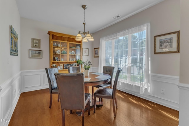 3400 Secretariat Way, Raleigh, NC 27614 - dining area with a chandelier, a wainscoted wall, wood finished floors, and a decorative wall
