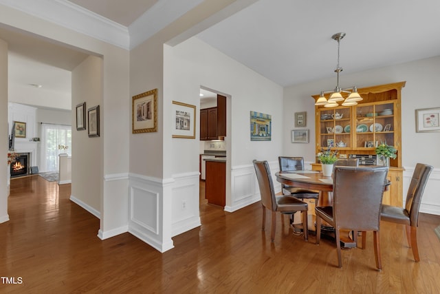 3400 Secretariat Way, Raleigh, NC 27614 - dining space with wood finished floors, a warm lit fireplace, and a wainscoted wall