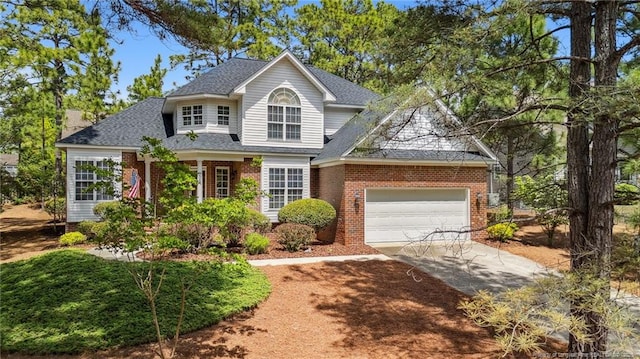 202 Juniper Creek Blvd, Pinehurst, NC 28374 - traditional home featuring concrete driveway, brick siding, an attached garage, and roof with shingles
