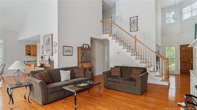 202 Juniper Creek Blvd, Pinehurst, NC 28374 - living area with a high ceiling, stairway, light wood-style flooring, and baseboards
